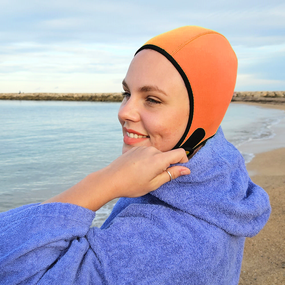 orange thermal swimming hat on beach
